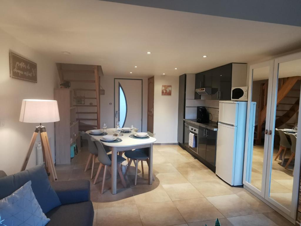 uma cozinha e sala de estar com uma mesa e um frigorífico em la baie le Rue em Rue