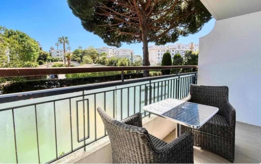 un patio avec deux chaises et une table sur un balcon dans l'établissement Superbe studio lumineux sur Cannes avec terrasse ! à quelques minutes de la célèbre rue d'Antibes !, à Cannes