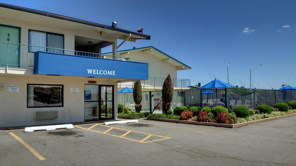 un edificio con un cartel de bienvenida en un aparcamiento en Rodeway Inn Fort Smith I-540, en Fort Smith