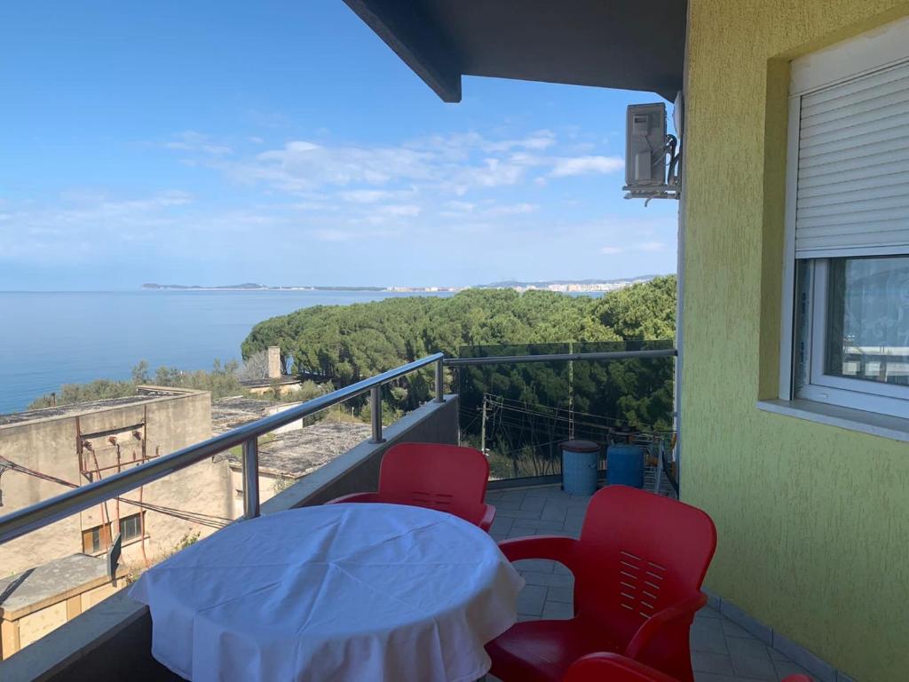 einen Balkon mit einem Tisch und Stühlen sowie Meerblick in der Unterkunft Apartament Orestiada in Vlorë