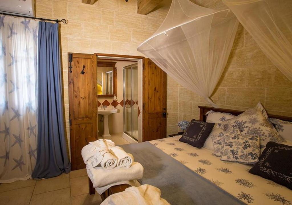 a bedroom with a bed with towels on it at Betty Cake B&B in Qala