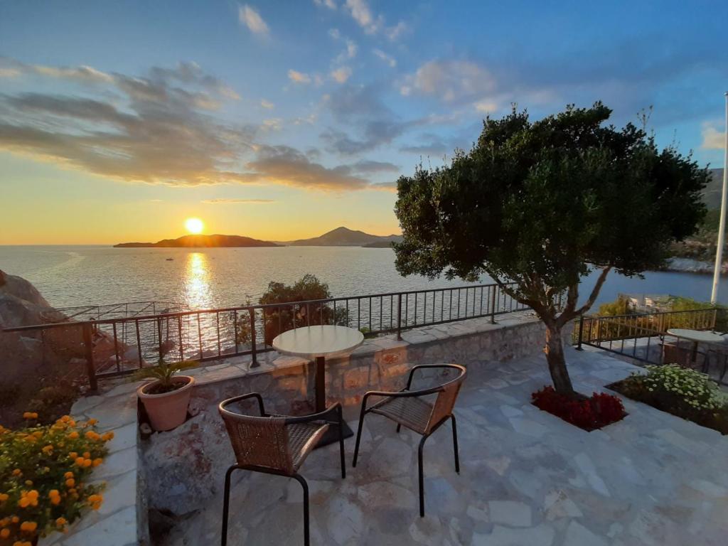 a table and chairs on a patio with a view of the ocean at Apartments Mitrovići Miločer in Sveti Stefan