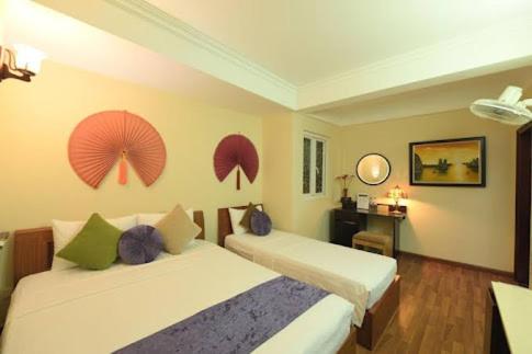 una camera con due letti e un ombrello sul muro di Holiday Lakeview Hotel a Hanoi