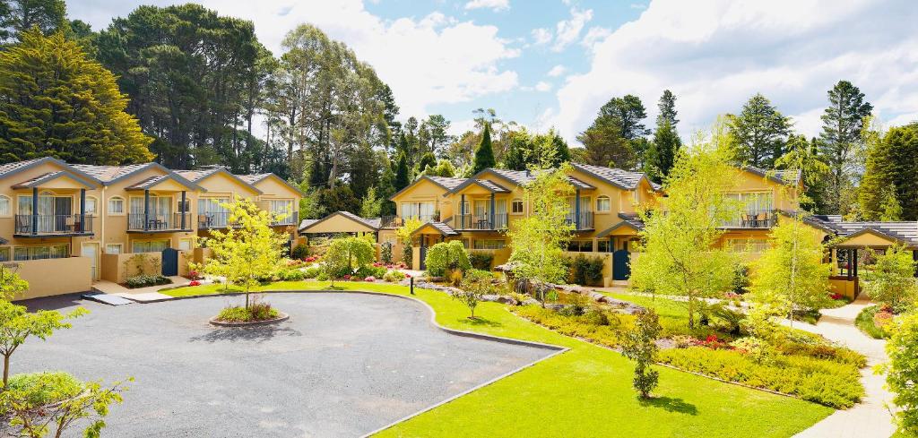 a row of houses in a yard with a courtyard at Falls Mountain Retreat Blue Mountains in Wentworth Falls