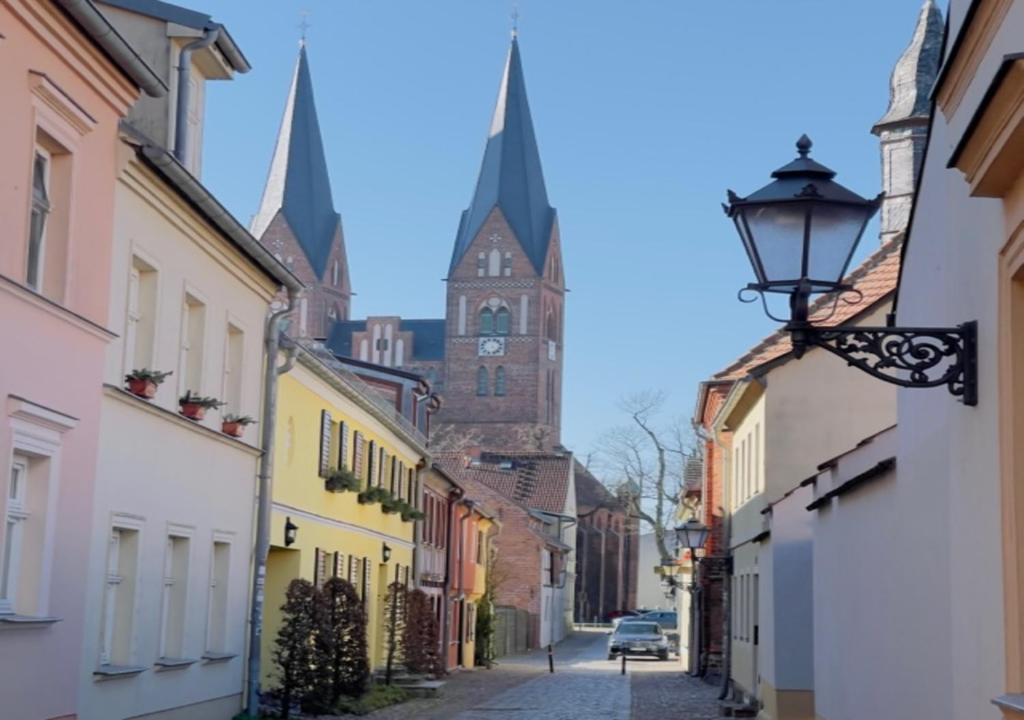 a street with a building with a clock tower at Ferienwohnung Kleinod in Neuruppin