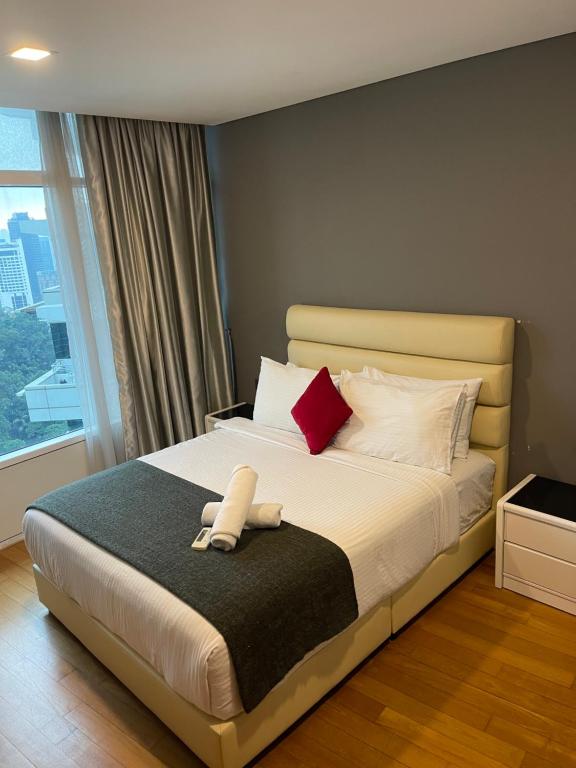 a bedroom with a bed with red and white pillows at Vortex Suites Klcc by Rit Villa in Kuala Lumpur