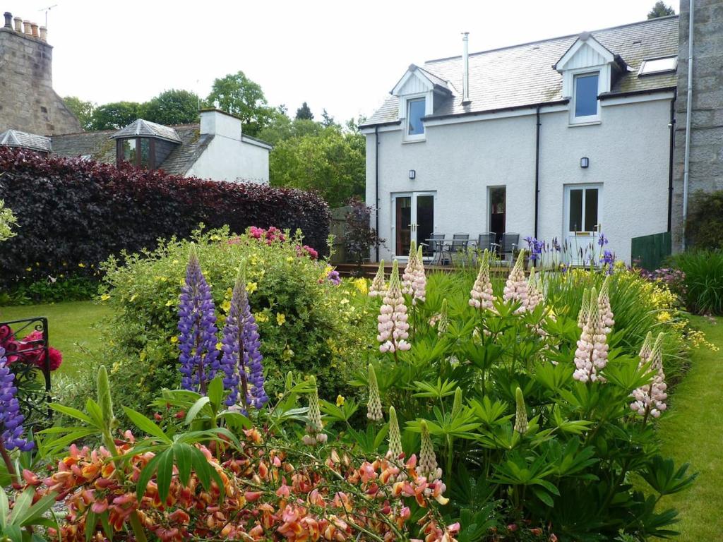 a garden with flowers in front of a house at Tulach Ard in Grantown on Spey