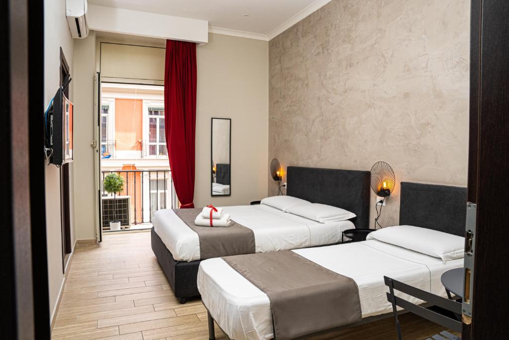 ナポリにあるNapoli City Roomsのベッド2台とテレビが備わるホテルルームです。