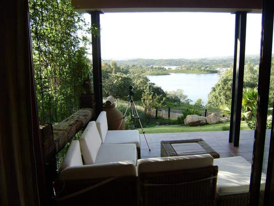 a living room with a couch and a view of a lake at Casa con encanto frente al lago in El Ronquillo