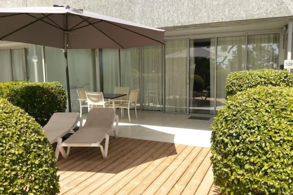 une terrasse avec une table, des chaises et un parasol dans l'établissement Costa Plana apartment 528 (3km from Monaco), à Cap d'Ail