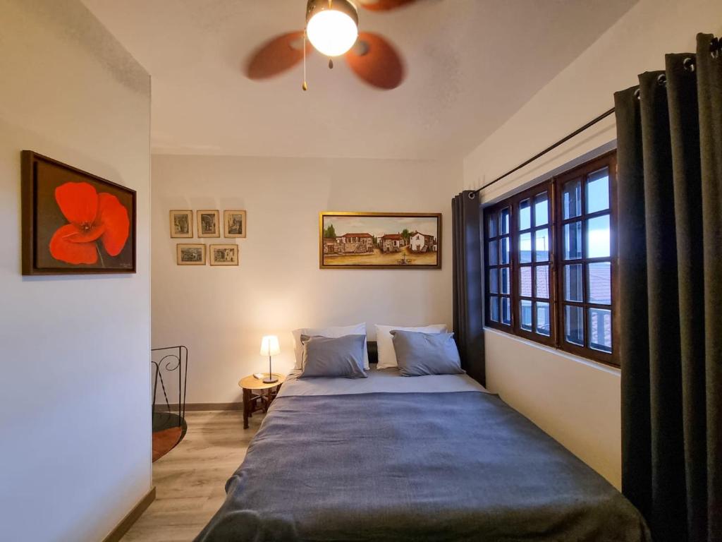 una camera da letto con un letto e un ventilatore a soffitto di Casa do Beco B&B Douro - Guest House a Parambos