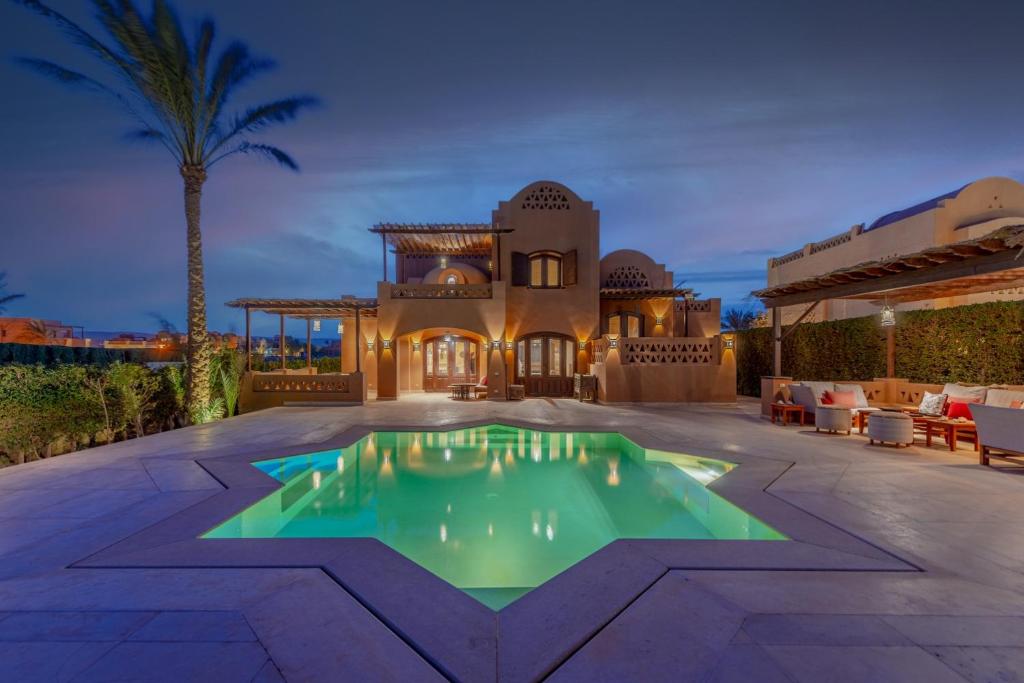 uma vista exterior de uma casa com piscina em Chic 3BR Villa West Golf with Pool, Lagoon View & Guest House em Hurghada