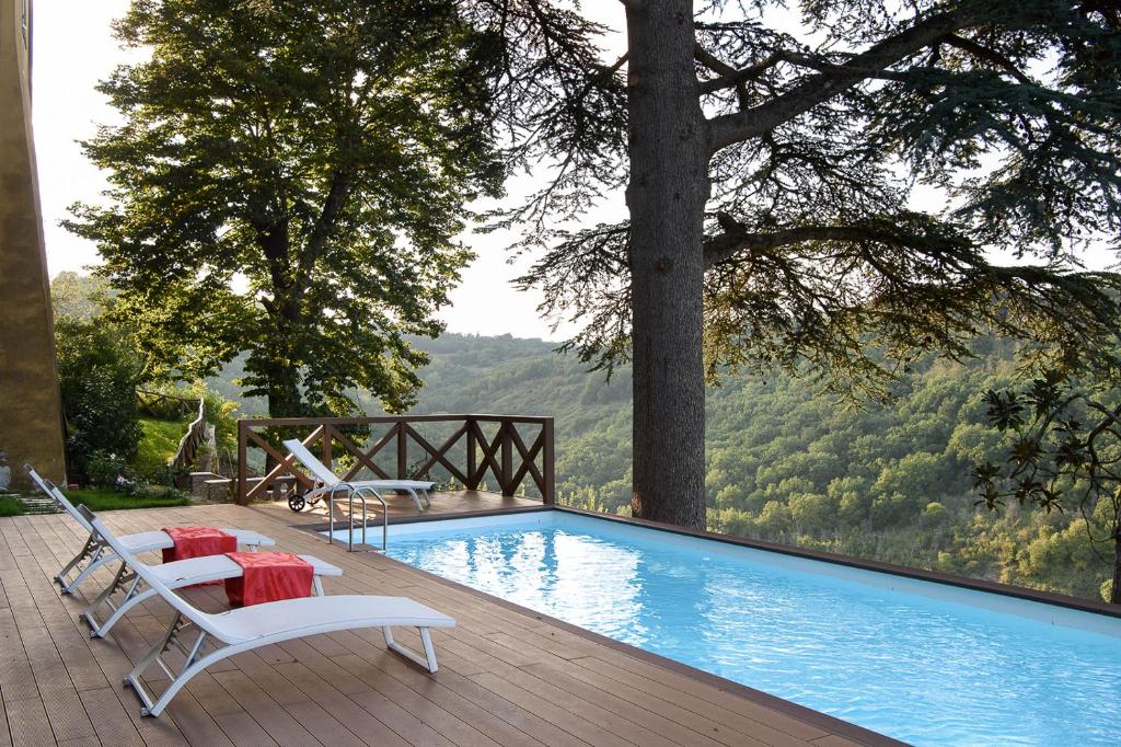 una piscina con 2 sillas y una mesa al lado en Il Castello di San Michele, en San Michele in Teverina