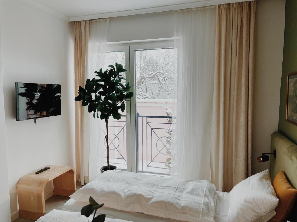 a bedroom with a bed and a large window at Anna apartment in Subotica