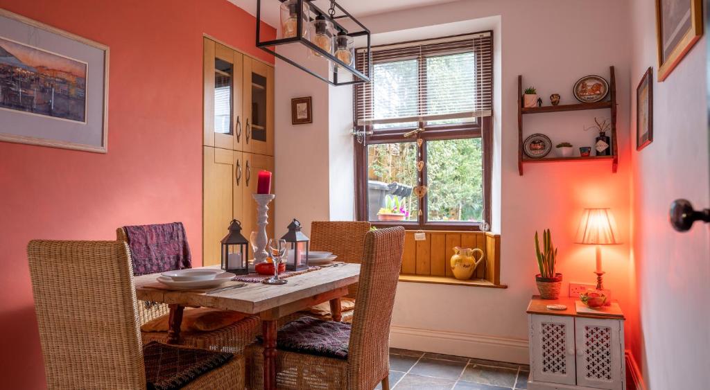 Kasbah cosy cottage Kendal في كندال: غرفة طعام مع طاولة وكراسي خشبية