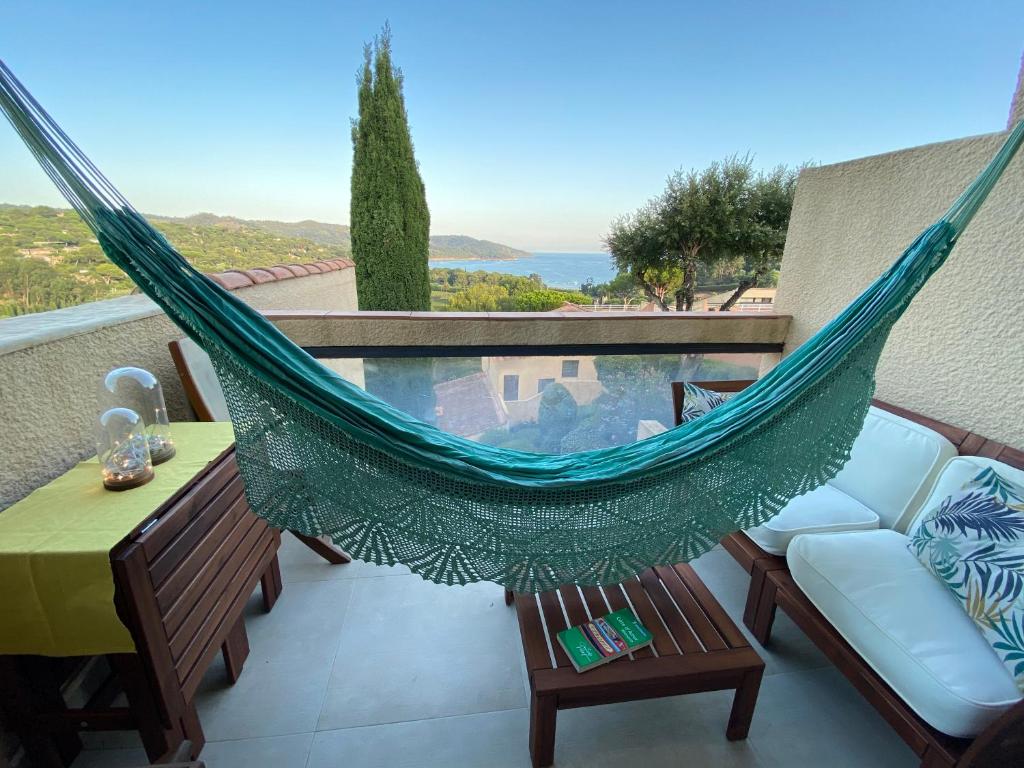 a hammock on a balcony with a pool at Appartement vue mer à Gigaro, La Croix-Valmer in La Croix-Valmer