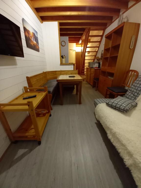 Appartement Mont Dore tout confort, 2 pièces, 4 personnes في لو مونت دوري: غرفة معيشة مع أريكة وطاولة