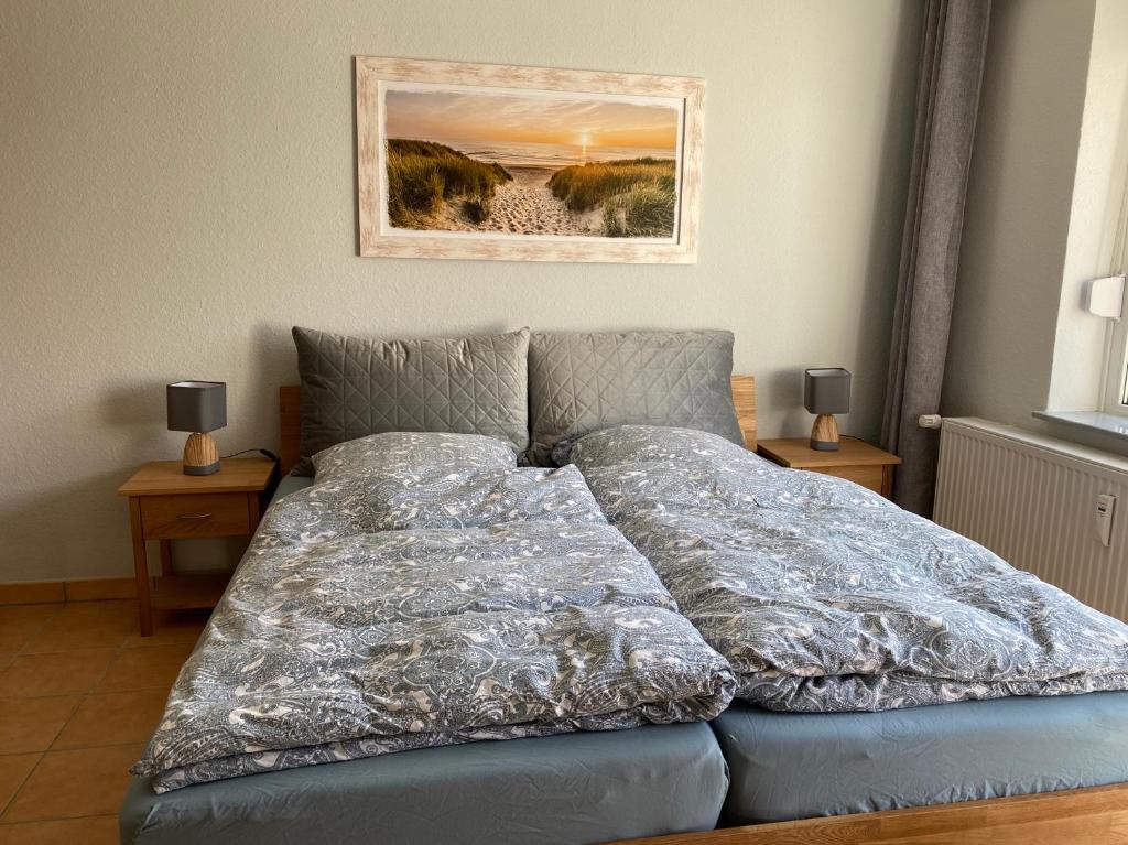 een bed met een deken erop in een slaapkamer bij Ferienapartment Rosengrund in Büsum