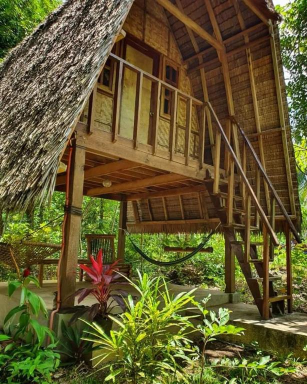 ein Baumhaus mit einer Treppe im Garten in der Unterkunft Lazy Lizard Hostel in Siquijor