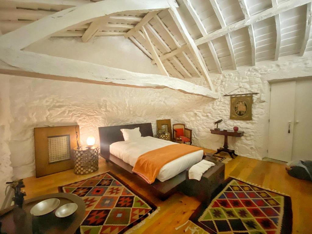 a bedroom with a king sized bed in a stone wall at Casa do Cruzeiro in Paredes de Coura
