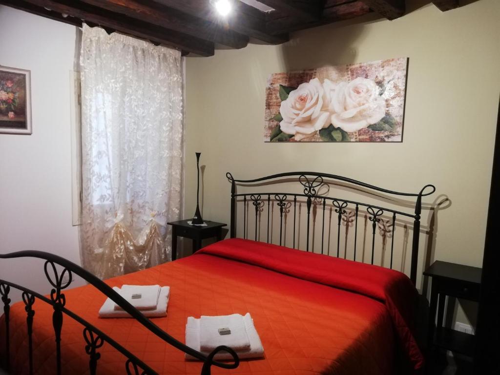 a bedroom with a bed with a red bedspread at Ca al Campanile in Venice