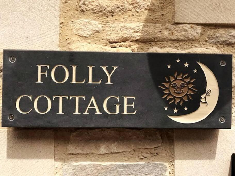 un cartel en una pared que lee cabaña voluminosa en Folly Cottage & The Old Forge en Colerne