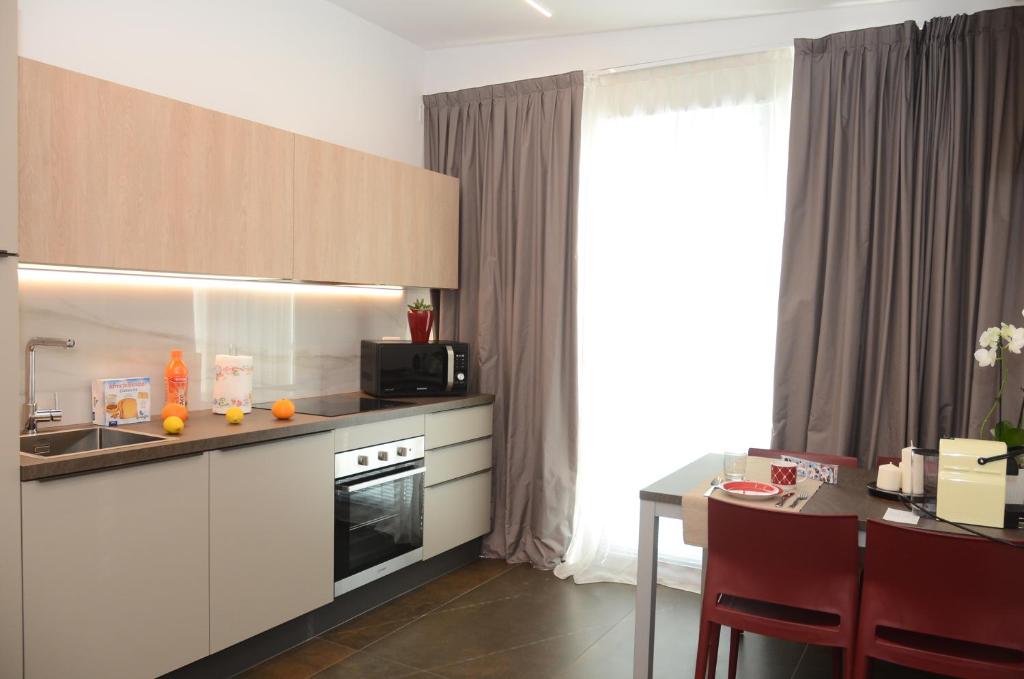 une cuisine avec des placards blancs et une table avec une table dans l'établissement Exclusive Home 1, à Misano Adriatico