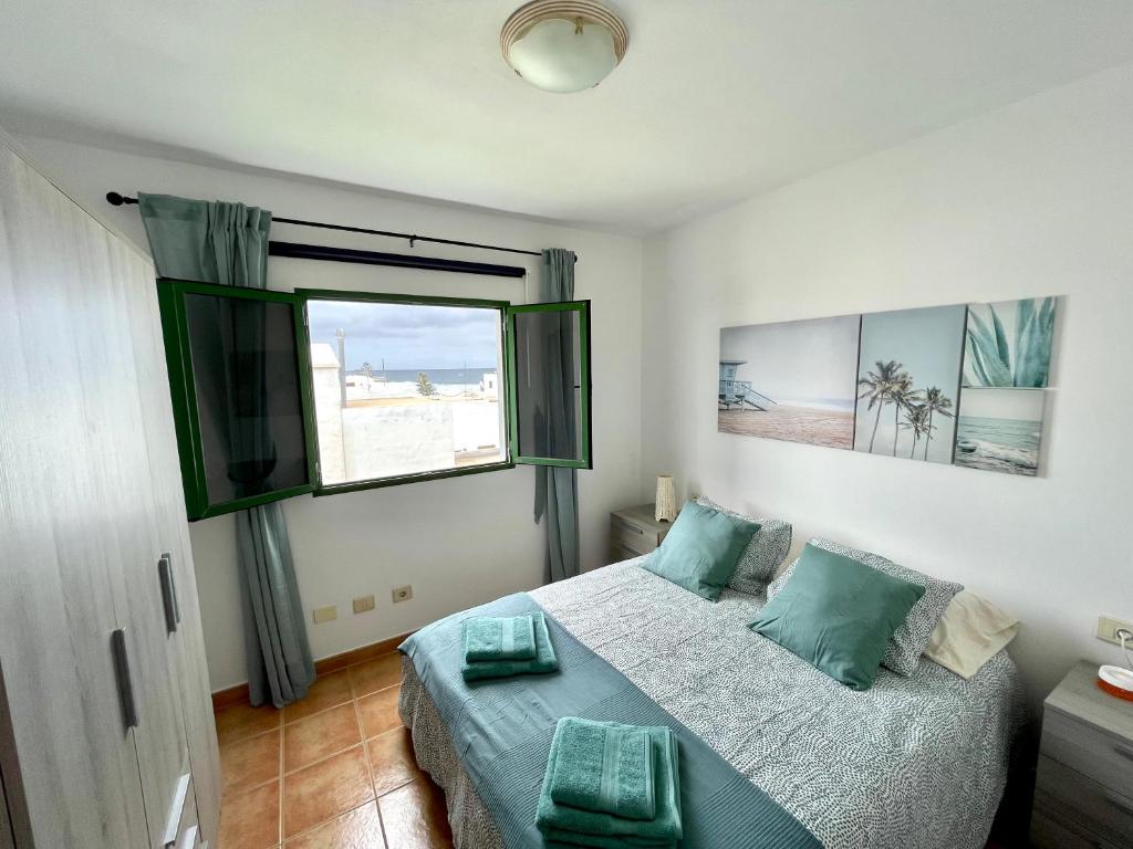 a bedroom with a bed and a large window at Maresía Apartamento in El Golfo