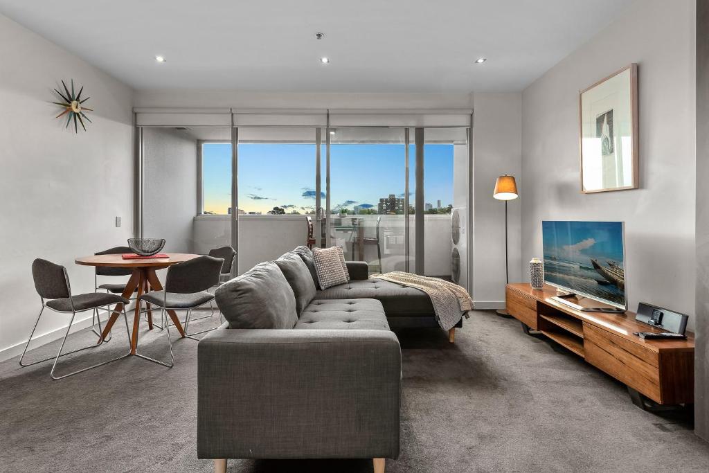 uma sala de estar com um sofá e uma mesa em Exclusive Stays - SXY em Melbourne