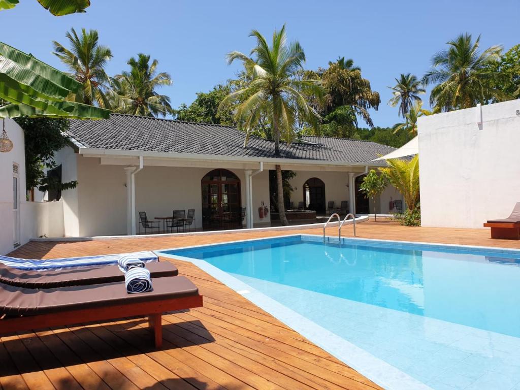 a swimming pool in front of a house at Bella Vita in Aluthgama