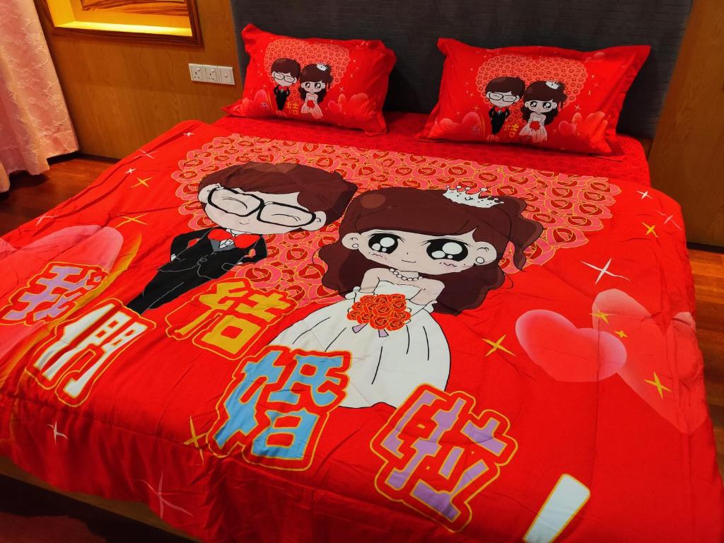 una cama roja con una novia y un novio en ella en R&S Homestay Sibu - Wedding House with Large Parking Area and High Speed Unifi en Sibu