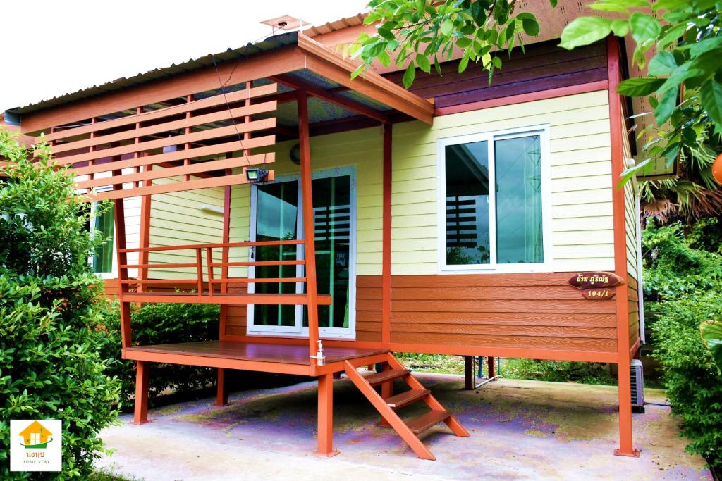 a tiny house with a porch and a deck at นงนุช โฮมสเตย์ & รีสอร์ท บุรีรัมย์ in Buriram
