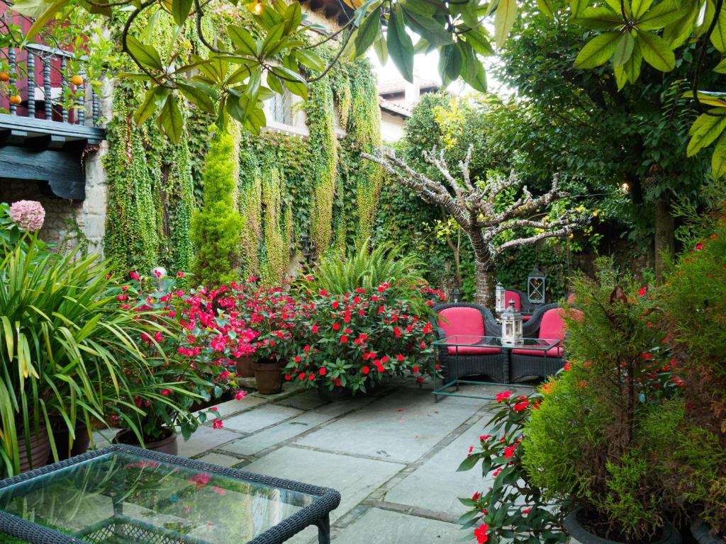 a garden area with benches and plants at Hotel Casa del Marqués in Santillana del Mar