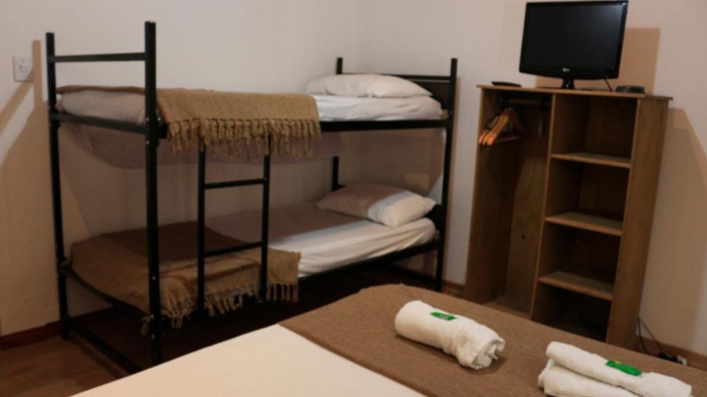 a room with two bunk beds and a tv at Pousadinha Copacabana in Rio de Janeiro