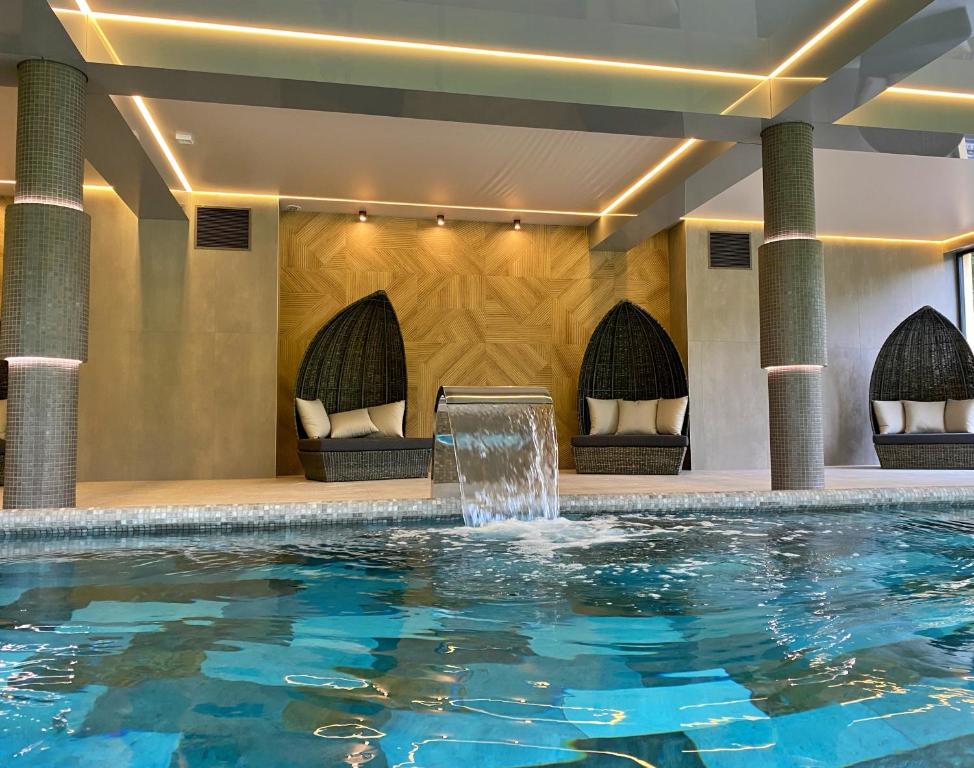 a swimming pool with a fountain in a hotel at Oasis Resort & Spa in Rewal