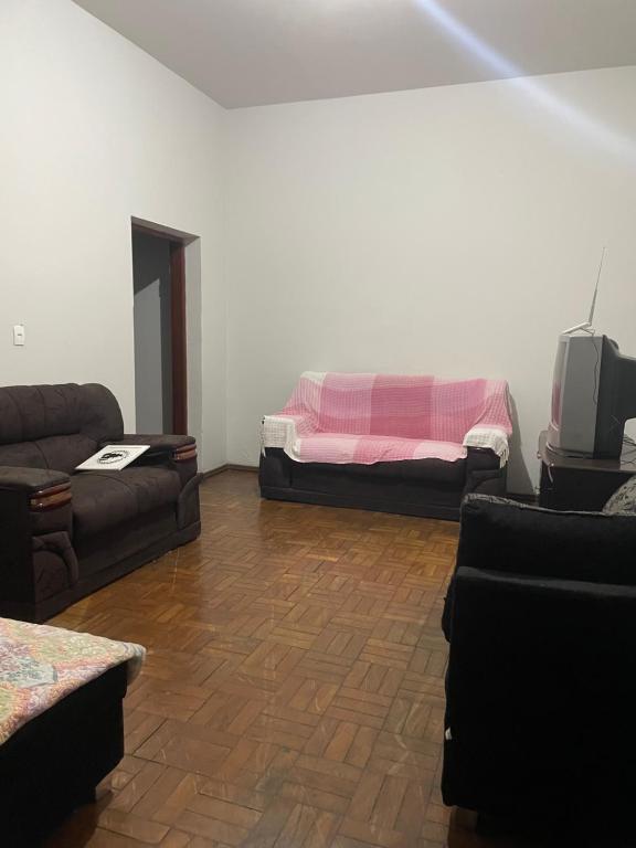 a living room with a couch and a bed at Apartamento Temporada in Passos