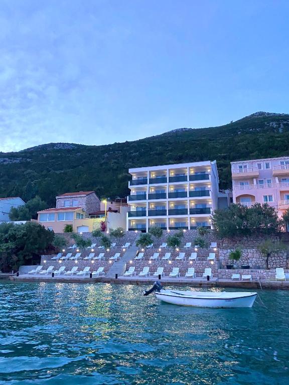 ein Boot im Wasser vor einem Gebäude in der Unterkunft Villa Millene in Neum