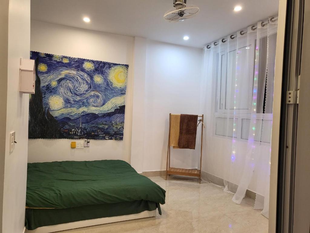 Un dormitorio con una pintura en la pared y una cama en BA CON ECH Home and Stay- No 28 lane 259 Nguyen Duc Canh en Hai Phong