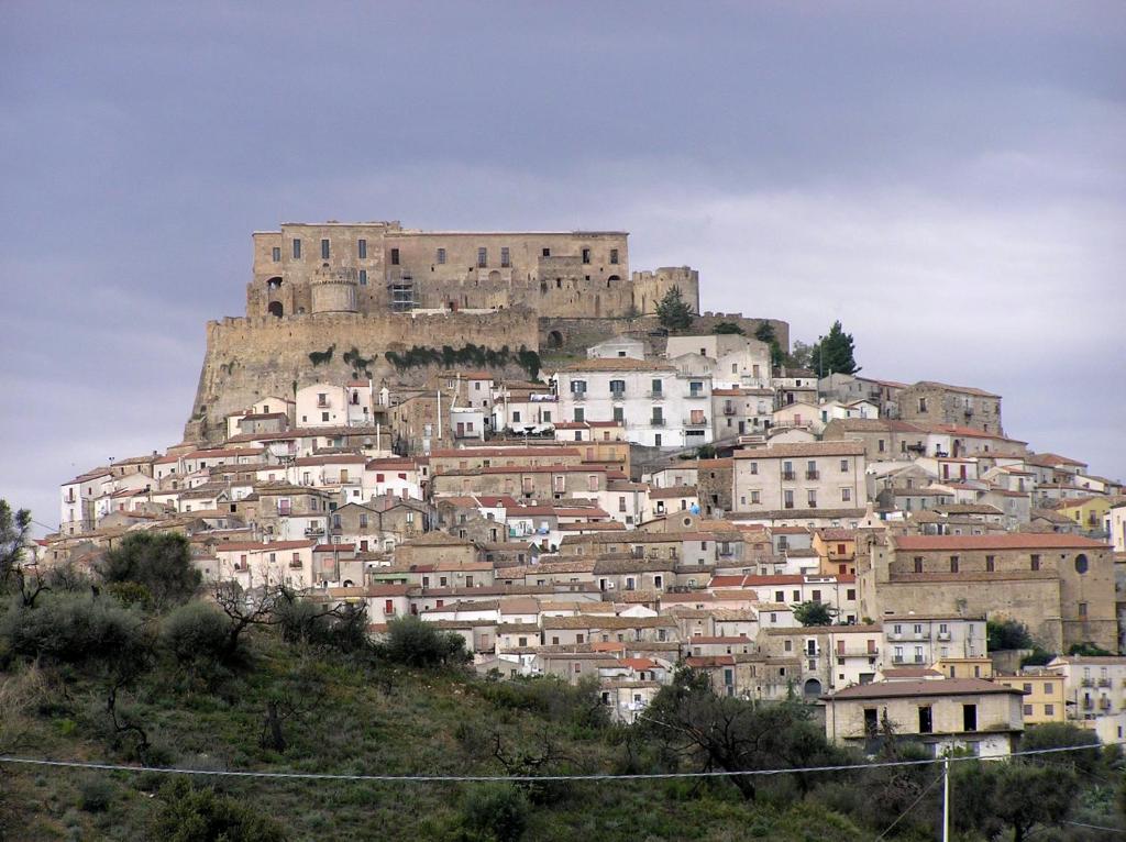 una ciudad en la cima de una colina con un castillo en Giro di vite, en Rocca Imperiale