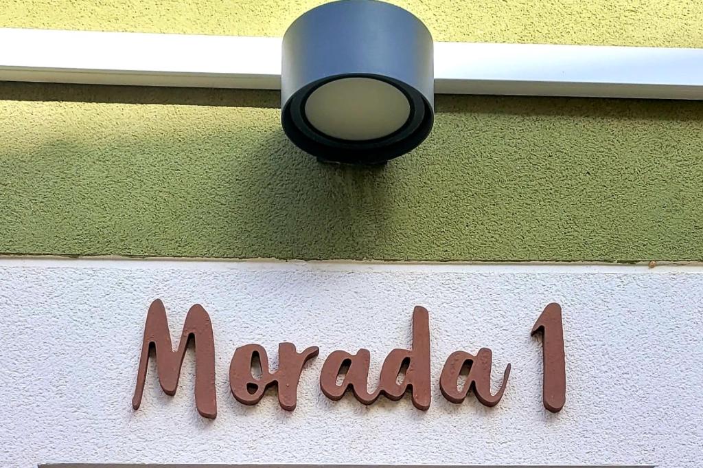 una luz en el lateral de un edificio con una señal en Morada 1 en Casas del Cerro