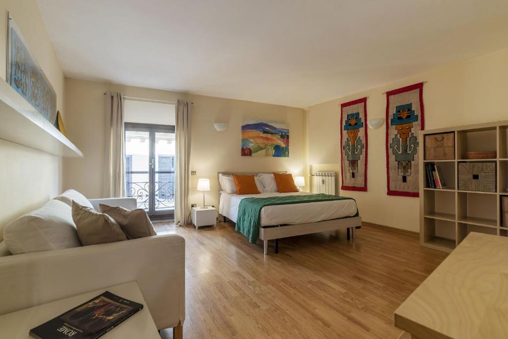 HospitalityRome Navona Studio Apartment في روما: غرفة معيشة مع سرير وأريكة