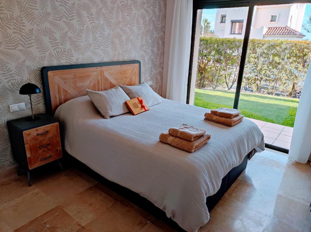 a bedroom with a bed with two towels on it at LUXURY GROUND FLOOR RODA GOLF & BEACH RESORT APARTMENT in Roda