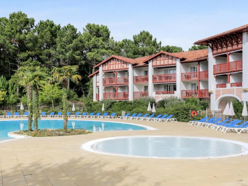 un complexe avec une piscine et des chaises dans l'établissement Location Biscarrosse Lac, à Biscarrosse