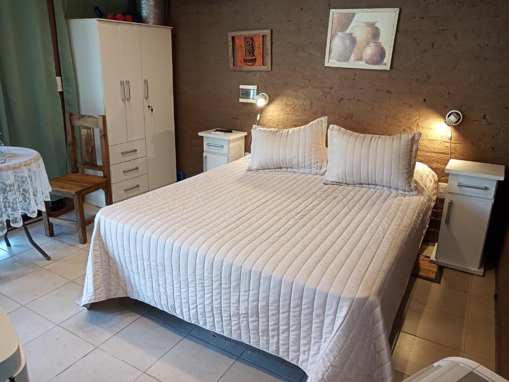 una camera da letto con un grande letto con lenzuola bianche di Departamento para relax y descanso a Ciudad Lujan de Cuyo