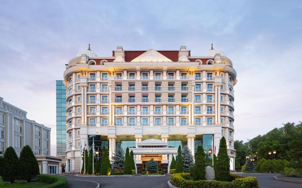 a large white building with a lot of windows at Rixos Almaty Hotel in Almaty
