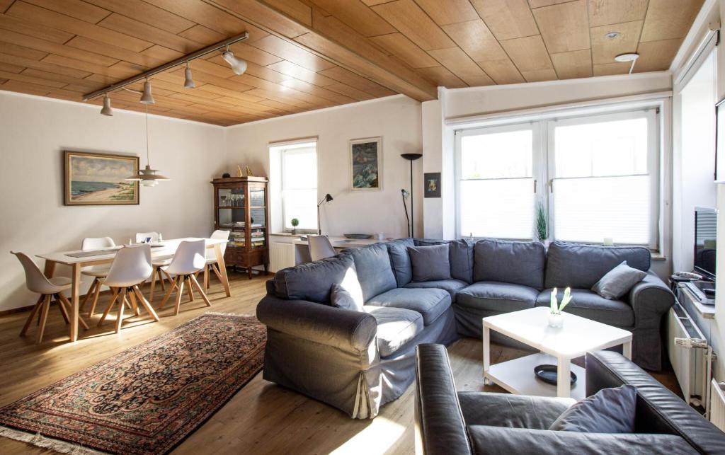 Una sala de estar con un sofá azul y una mesa. en Lütt Hus Erna, en Fehmarn
