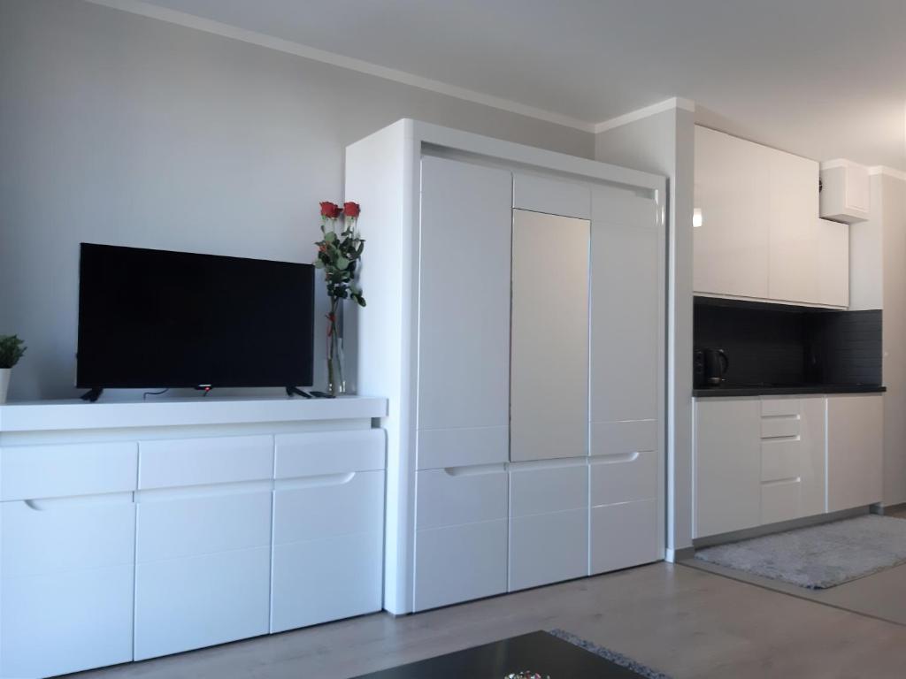 una cocina blanca con TV en un armario blanco en Apartament Pianista en Varsovia
