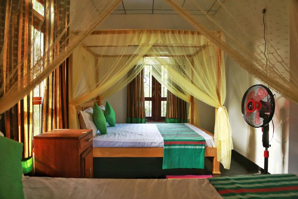 1 dormitorio con cama con dosel en una habitación en City Elephant Family Resort en Udawalawe