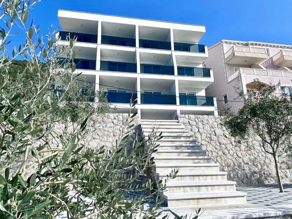 un edificio blanco con escaleras delante en Villa Millene en Neum