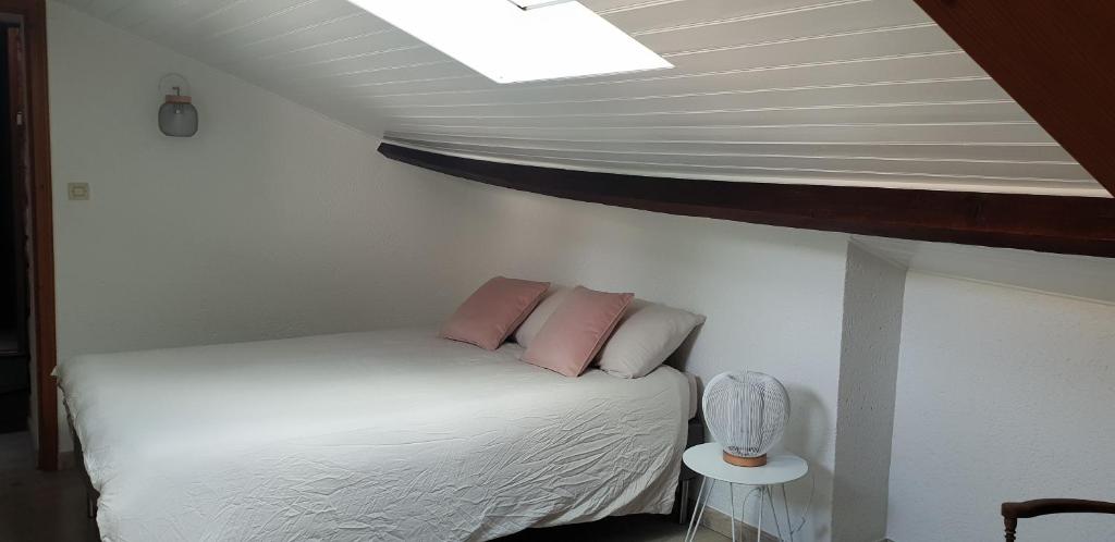 una camera con un letto con due cuscini rosa di Le logis de la Forge à 10 min du Puy duFou a Mortagne-sur-Sèvre